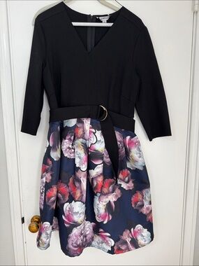 Black top dress with navy and multicolor floral skirt with attached belt.